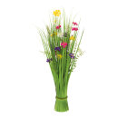 Bundle of grass with spring flowers out of...